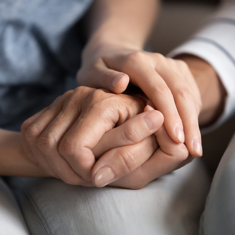 I know you can. Close up of millennial woman grown daughter, grandchild or younger friend holding tight hand of old mother, grandmother, elder relative or colleague helping to overpass life problems